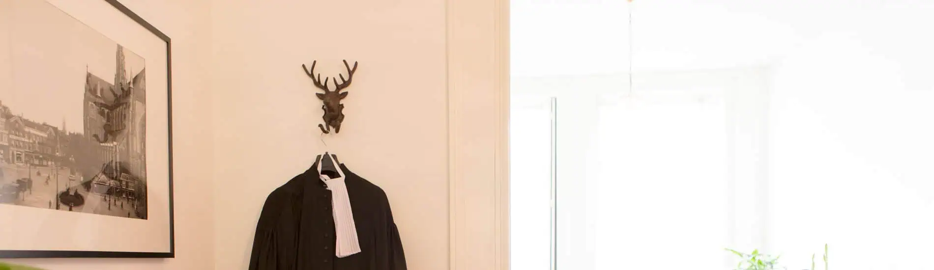 Kantoorruimte met muurdecoratie, kleding en raam.