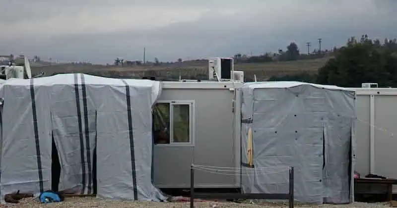 Tijdelijke woonunits op een veld, geschikt voor noodopvang of tijdelijke huisvesting.