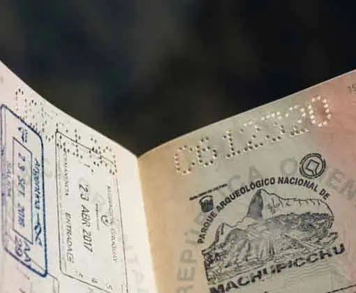 Reisdocument met stempel en handtekening op een vage achtergrond.